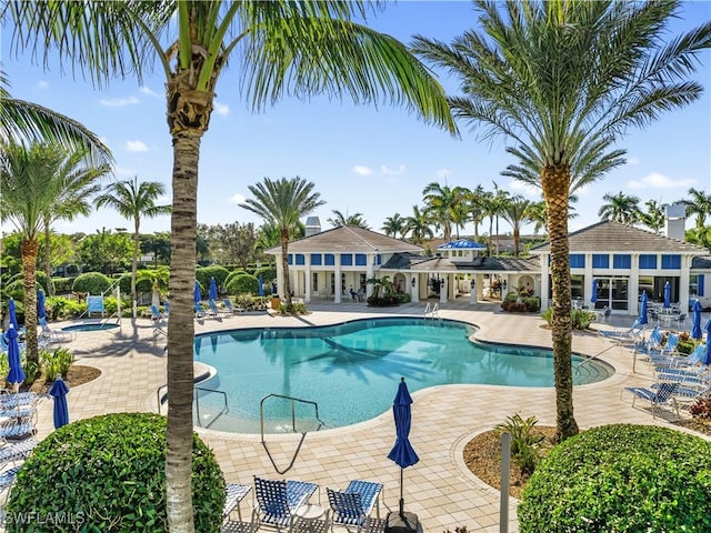 view of pool with a hot tub and a patio