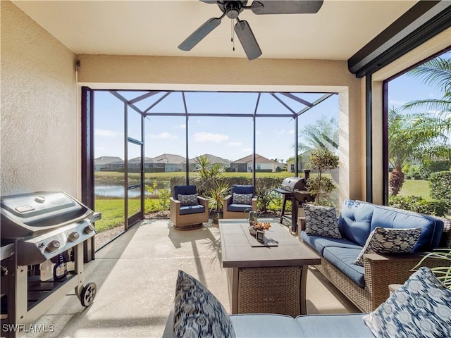 sunroom / solarium featuring a water view and ceiling fan