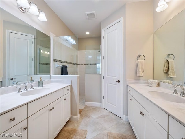 bathroom with a tile shower and vanity