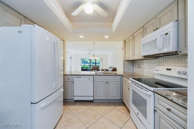 kitchen featuring sink, tasteful backsplash, ornamental molding, a tray ceiling, and white appliances