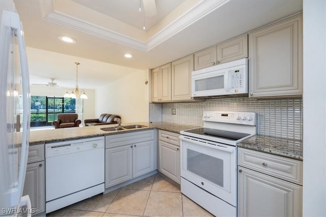 kitchen featuring sink, white appliances, a raised ceiling, ceiling fan, and backsplash