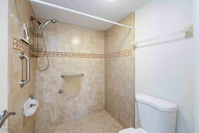 bathroom featuring a tile shower and toilet