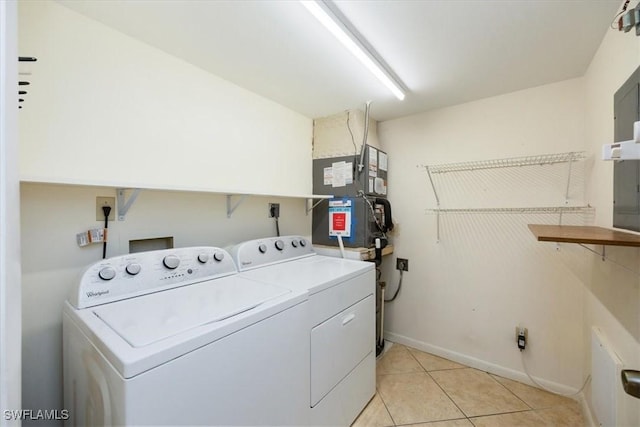 clothes washing area featuring washing machine and dryer, heating unit, and light tile patterned floors