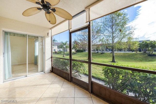 unfurnished sunroom with ceiling fan