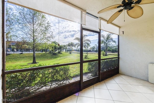 unfurnished sunroom with ceiling fan