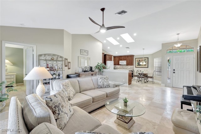 living room featuring vaulted ceiling with skylight and ceiling fan