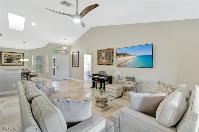 living room with ceiling fan, a healthy amount of sunlight, and lofted ceiling with skylight