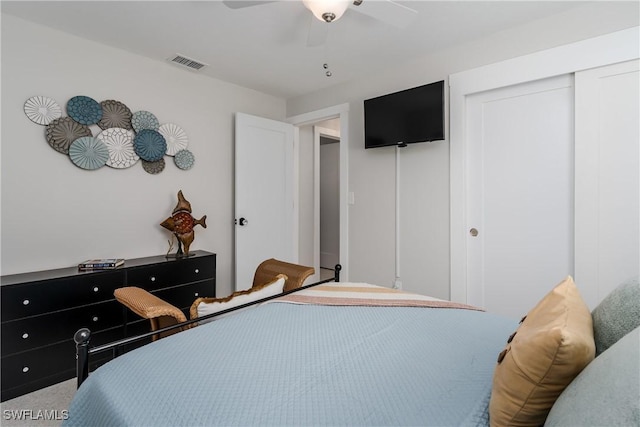 carpeted bedroom with ceiling fan and a closet