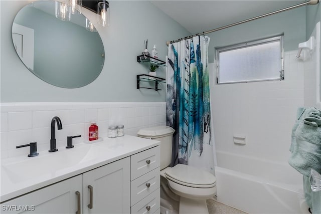 full bathroom with vanity, tile walls, shower / bath combo with shower curtain, and toilet