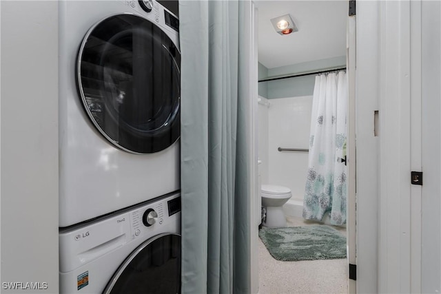 laundry area featuring stacked washer / drying machine