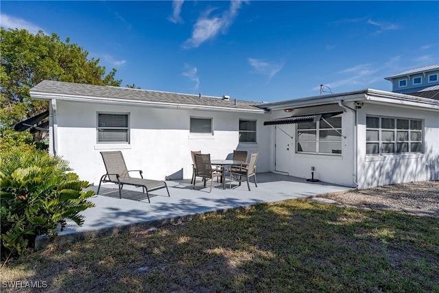 back of house with a patio area and a lawn