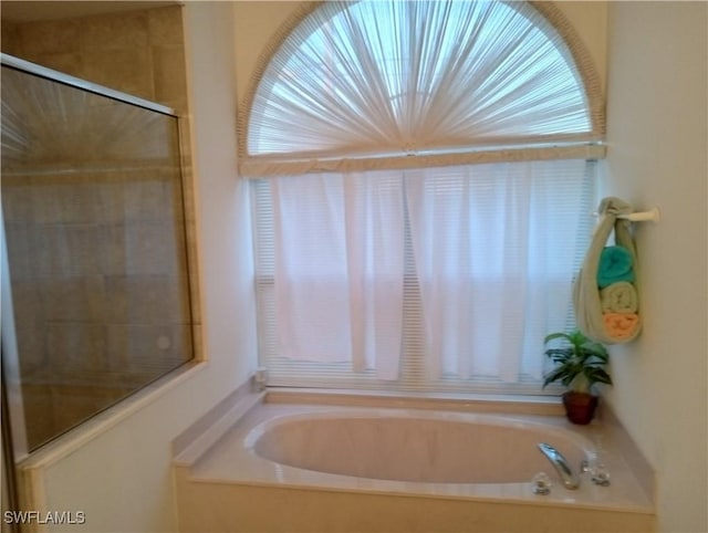 bathroom featuring independent shower and bath and plenty of natural light