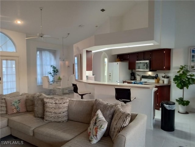 tiled living room featuring a wealth of natural light, high vaulted ceiling, and ceiling fan