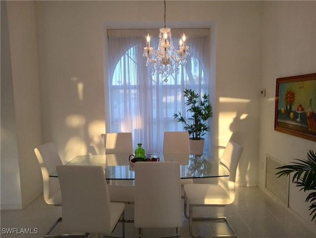 tiled dining room featuring a chandelier