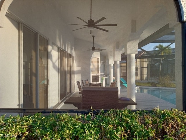 view of patio / terrace with ceiling fan and glass enclosure