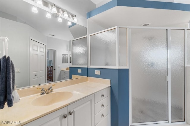 bathroom with vanity and a shower with door