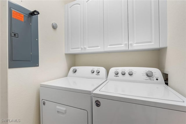 laundry area featuring cabinets, electric panel, and washer and clothes dryer