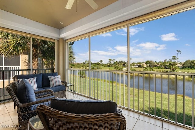 sunroom / solarium featuring a water view, plenty of natural light, and ceiling fan