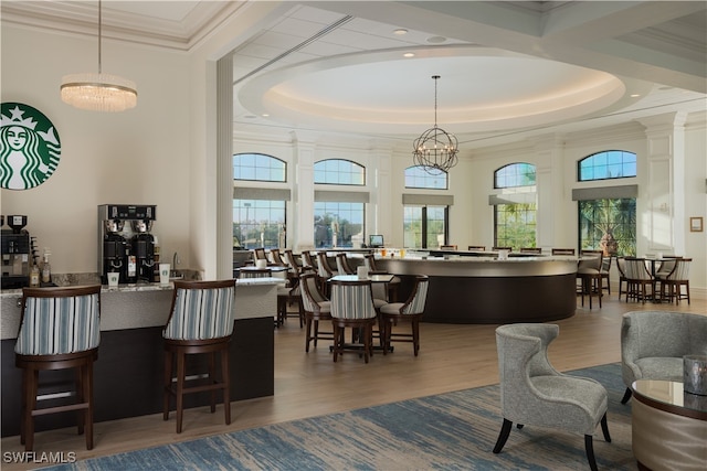 bar featuring hanging light fixtures, hardwood / wood-style floors, and an inviting chandelier