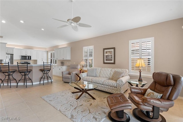 living room with ceiling fan, plenty of natural light, and light tile patterned floors