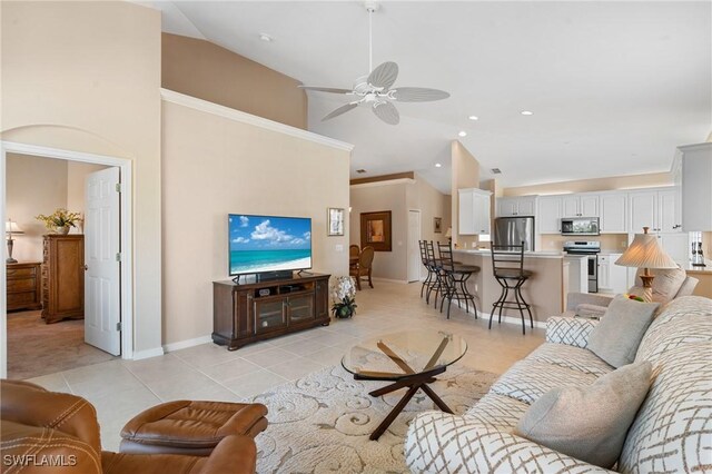 tiled living room with ceiling fan and high vaulted ceiling