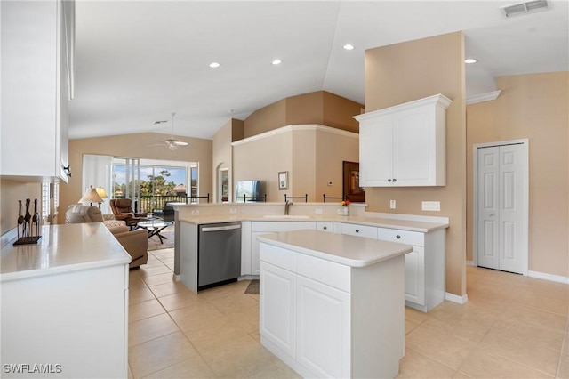 kitchen with white cabinetry, a kitchen island, stainless steel dishwasher, and kitchen peninsula