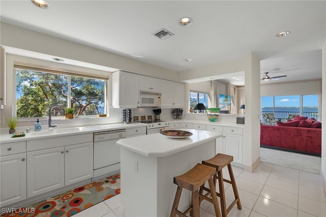 kitchen featuring sink, white appliances, and white cabinets