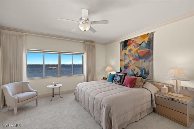 carpeted bedroom with a water view, ceiling fan, and ornamental molding