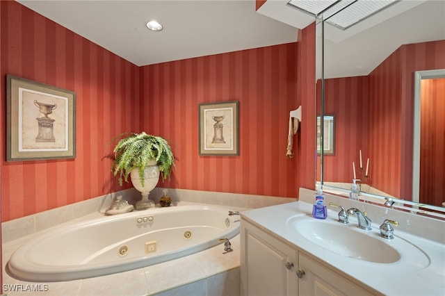 bathroom featuring a relaxing tiled tub and vanity