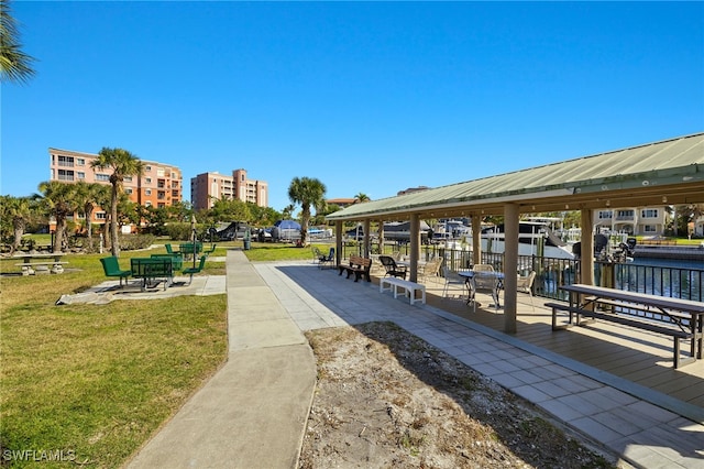 view of home's community featuring a patio area, a lawn, and a water view