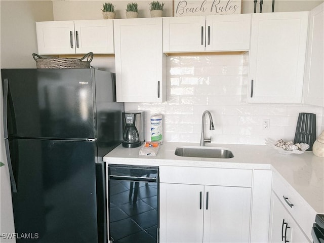 kitchen with sink, black appliances, and white cabinets