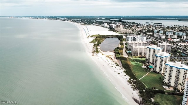 birds eye view of property featuring a water view and a beach view