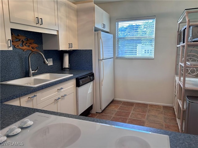 kitchen featuring sink, backsplash, white cabinets, and white appliances