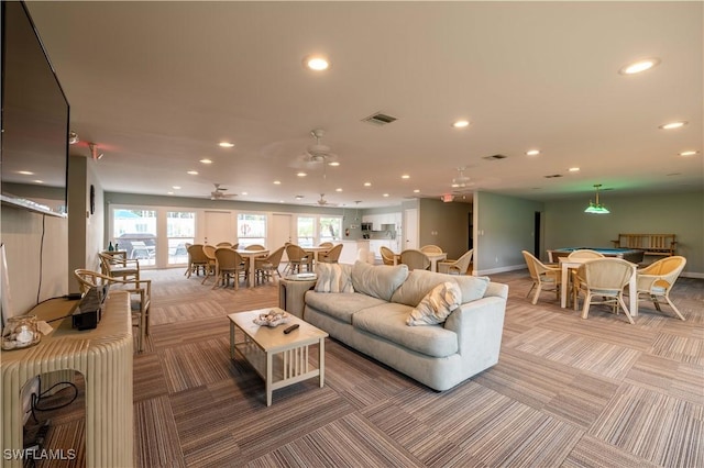 living room featuring ceiling fan and carpet