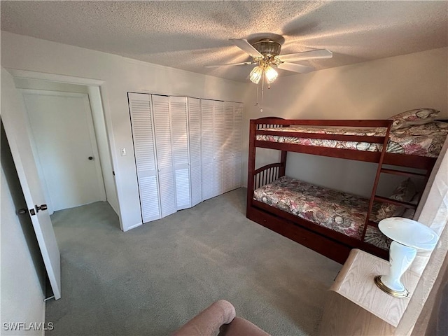 carpeted bedroom featuring ceiling fan, a textured ceiling, and a closet