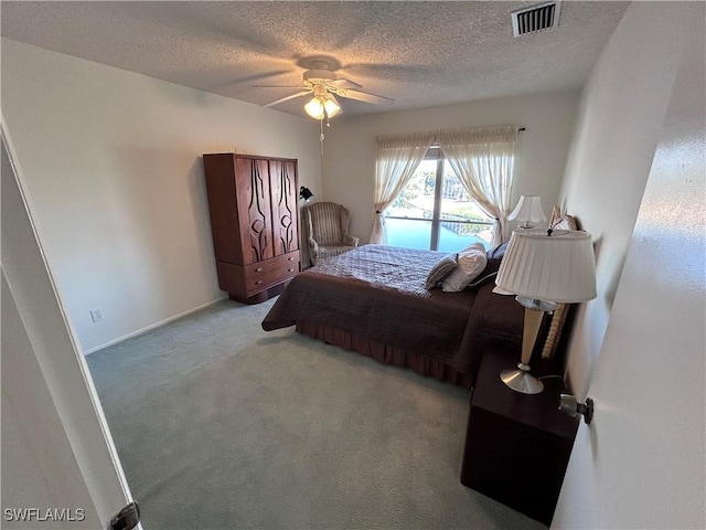 bedroom with ceiling fan, light carpet, and a textured ceiling