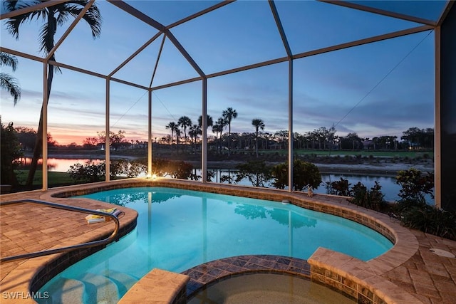 pool at dusk with a patio, an in ground hot tub, a water view, and glass enclosure