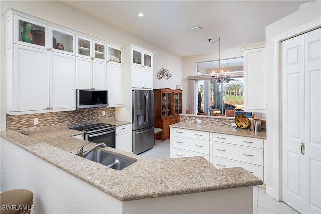 kitchen featuring sink, white cabinetry, stainless steel appliances, decorative light fixtures, and kitchen peninsula