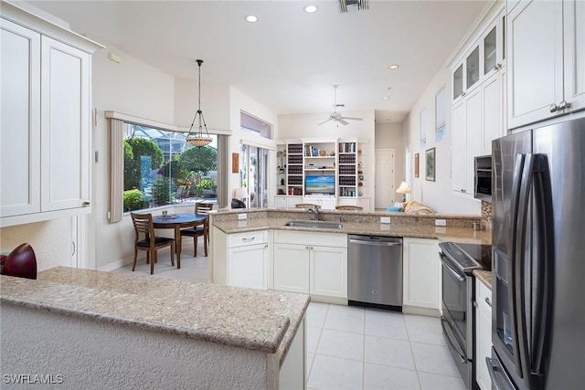 kitchen featuring appliances with stainless steel finishes, decorative light fixtures, white cabinetry, sink, and light tile patterned floors