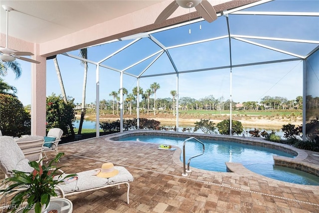 view of pool featuring a lanai, a patio area, ceiling fan, and a water view