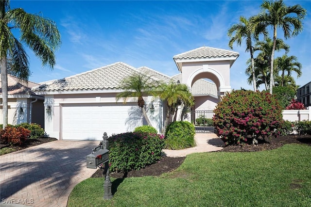 mediterranean / spanish-style home featuring a garage and a front yard