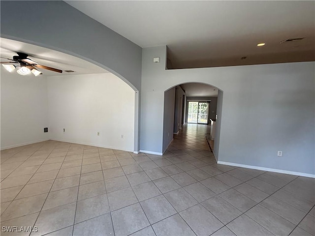 tiled empty room featuring ceiling fan