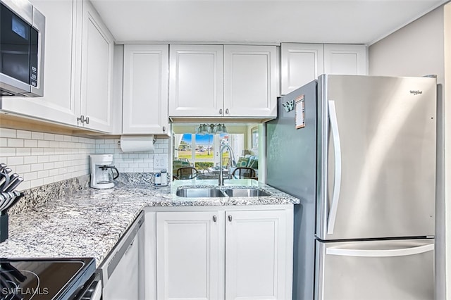 kitchen with tasteful backsplash, stainless steel appliances, sink, and white cabinets