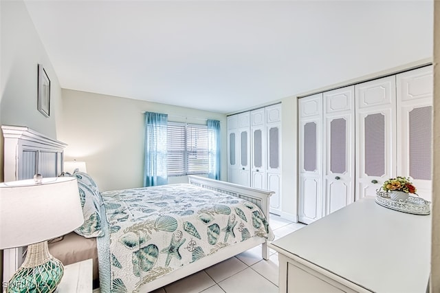 tiled bedroom featuring multiple closets