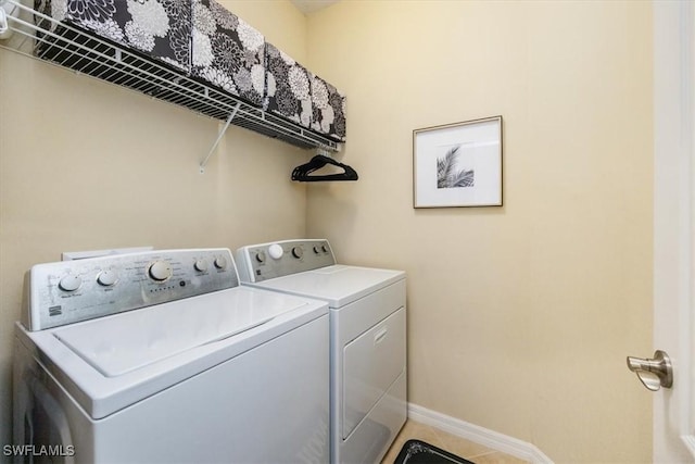 clothes washing area featuring tile patterned flooring and washing machine and dryer