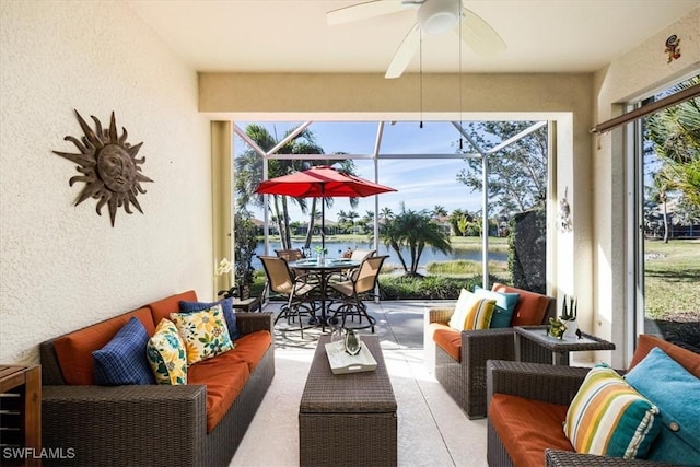 sunroom / solarium with a water view and ceiling fan