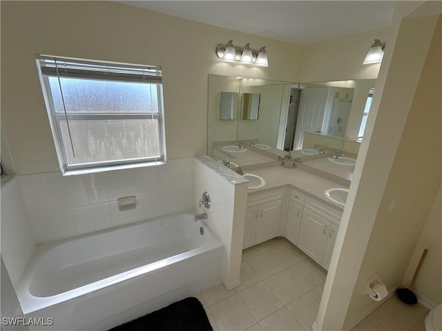 bathroom with a bathing tub, tile patterned floors, and vanity