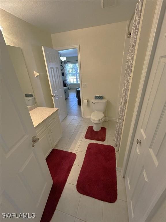 bathroom featuring vanity, tile patterned flooring, curtained shower, and toilet