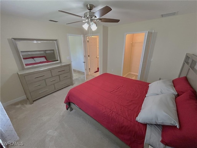 carpeted bedroom featuring a spacious closet and ceiling fan