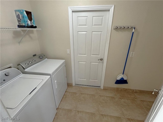 laundry room featuring light tile patterned flooring and washing machine and dryer